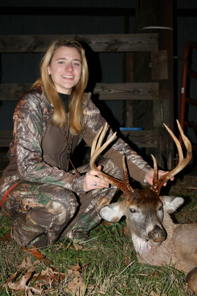 An image of a woman posing with a dead deer she has killed